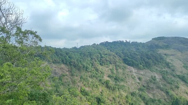 Panoramic view of misty green mountains and lush forest valleys in Nelliyampathy, Palakkad, Kerala