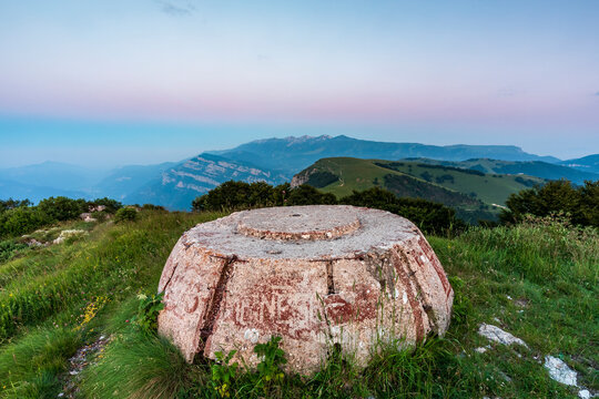 Historical concrete bunker ruins overlook alpine meadows and mountain peaks Monte Baldo Natural Park, Vignola mount-Corno della Paura, Brentonico, Trentino, Veneto, Italy.
