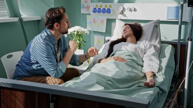 Despaired man sits waits for ill wife awakening in hospital ward