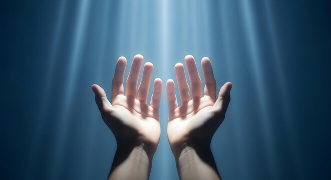 Hands reaching up to light. Prayer gesture in a spiritual atmosphere.