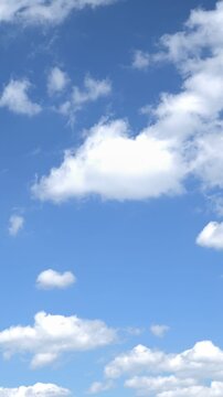 Vertical video of delicate white clouds moving quickly across the azure sky on a summer day