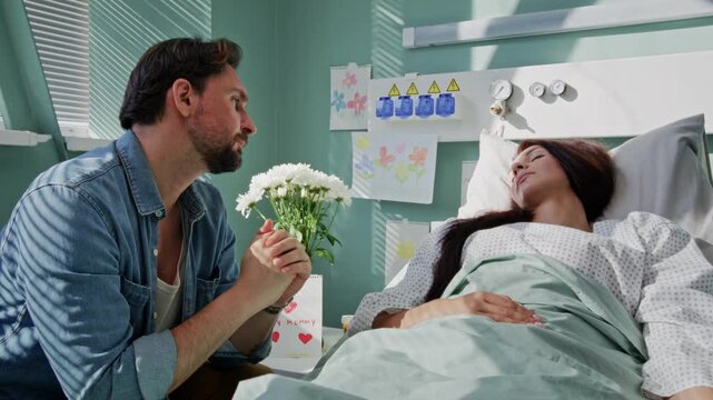 Pensive man sits near sleeping wife shows hope by gentle touching