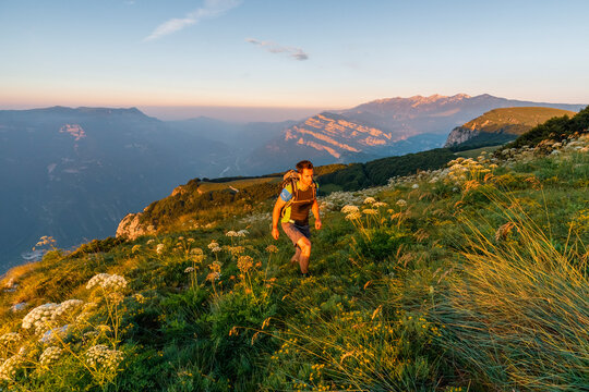 Hiker trekking on an alpine mountain meadow at sunset, embodying outdoor adventure and lifestyle, Vignola mount-Corno della Paura,Monte Baldo Natural Park, Brentonico, Trentino, Veneto, Italy.