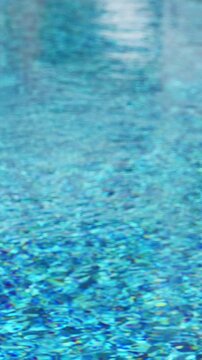 Clean water in swimming pool with reflections. Vertical footage
