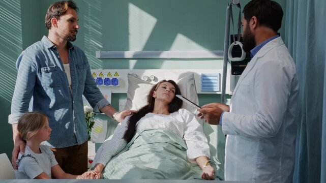 Loving family visits ill woman during doctor checkup in hospital