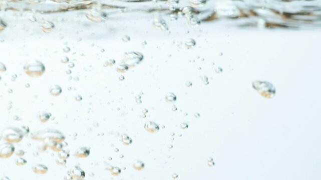 Slow motion shot of physalis fruits submerging into clean water with air bubbles