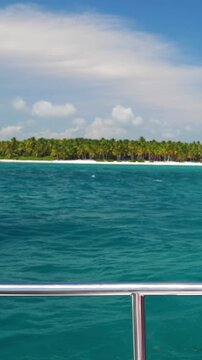 Catamaran boat sailing in Caribbean sea, view from motor yacht on blue water. Maritime cruising holiday. Vertical footage