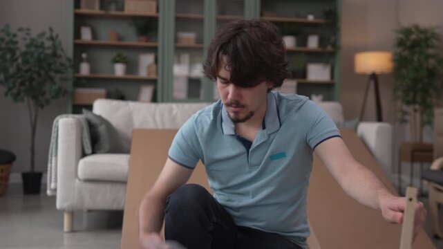 Frustrated man assembling new flat pack furniture