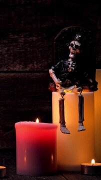 Skull and candles on wooden background. Jack-o-lantern on black background. Vertical footage