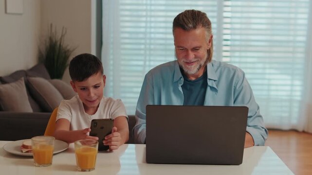 Father and Son Using Technology at Home