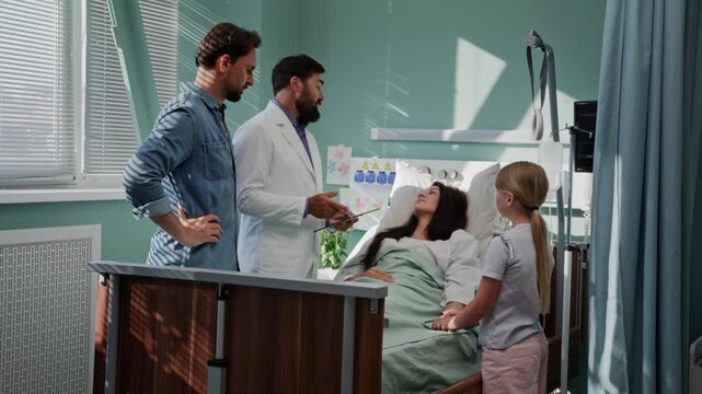 Doctor discusses patient recovery with family near hospital bed
