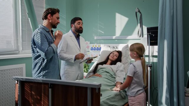 Concerned man listens as doctor explains female patient condition
