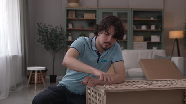 Young man assembling new flat pack furniture