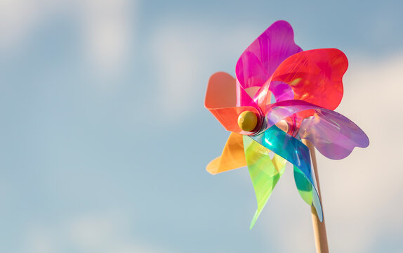 Summer or wind power renewable energy background, windmill or pinwheel against blue sky