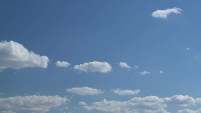 gentle white clouds move quickly across the azure sky on a summer day