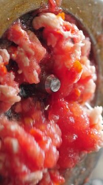 Cooking tomato paste in food grinder. Vertical footage
