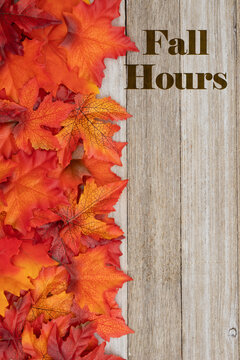 Fall Hours message with fall leaves on weathered wood