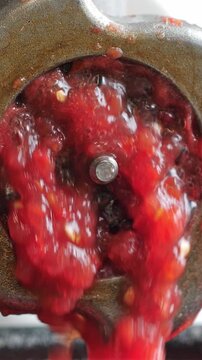 Cooking tomato paste in food grinding machine. Vertical footage
