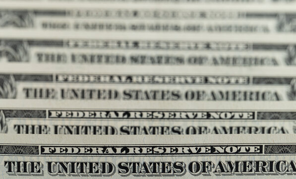 Macro shot of US dollar bills with Federal Reserve Note text and selective focus