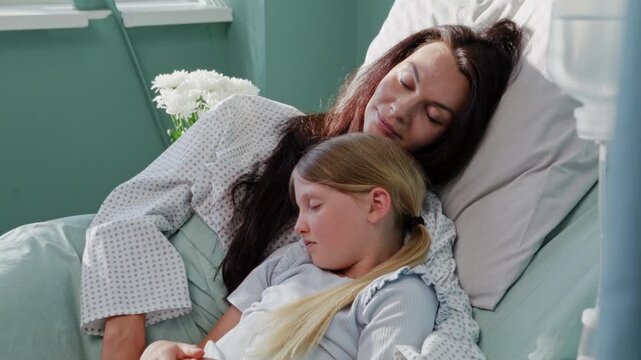 Mother embraces sleeping daughter at hospital recovery in ward