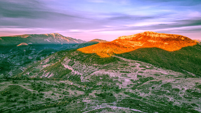 Golden Hour Panorama of Montagne de Buc, France
Stunning panoramic view of Montagne de Buc at sunset. Golden orange light bathes the rugged mountain slopes, creating a high contrast with deep shadows.