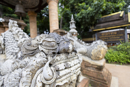 Ornate stone guardian sculpture temple entrance detailed carving serene atmosphere historic architecture