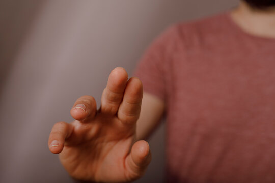Hand reaching out to touch a screen interface, implying digital interaction and engagement.
