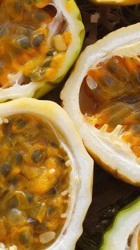 Passion fruit background with half cut chinola. Sliced maracuja. Tropical fruits backdrop. Vertical footage