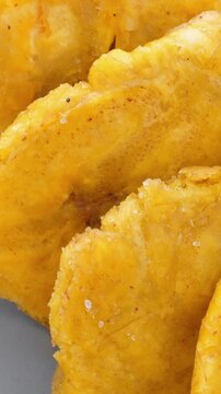 Fried platanos. Sliced and cooked tostones. Rotating. Vertical footage