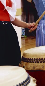 People, hands and learning with drums in class for music production, sound or taiko tradition. Group, instrument and playing with sticks for percussion rhythm, culture or musical audition together