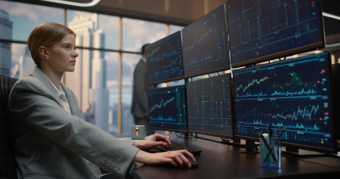 Arc Portrait of Female Stockbroker at a Desk Studies Stock Exchange Data on screen Terminals, Tracking Equity Graphs, Market Indices, Trading Analytics. Asset Management Company