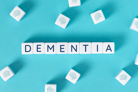 dementia word on blocks surrounded by brain icons on blue background