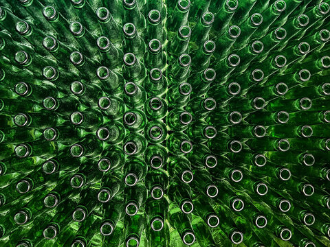 Abstract background of green glass bottles. Concept of glass recycling, reusable bottles, circular economy, bottle deposit return system (Pfand) and sustainable waste management.