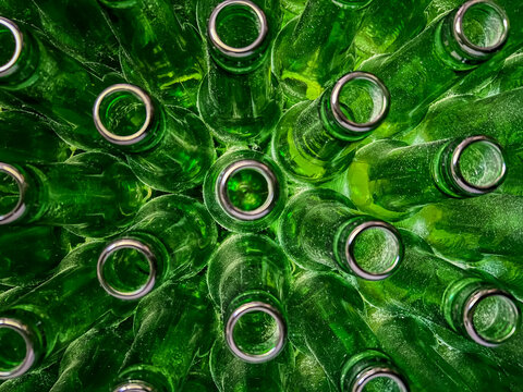 Abstract background of green glass bottles. Concept of glass recycling, reusable bottles, circular economy, bottle deposit return system (Pfand) and sustainable waste management.