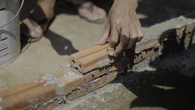 Close Up Of Laying Bricks With Cement Mortar