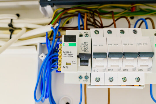 Extreme close-up of a dynamic RCD safety switch and circuit breakers within an open electrical panel, showing detailed neutral wire connections on a terminal block.