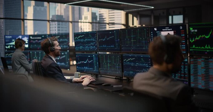 Trader Studies Stock Exchange Data and Investment Analytics at a Desk Surrounded by Computer Screens Tracking Capital Growth and S&P 500 Trends, Team Monitors Market Charts. Asset Management Company