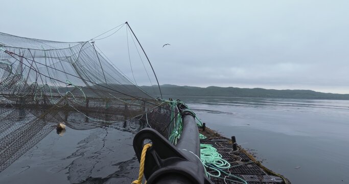 Large fish farm in the water with nets under cloudy sky as background