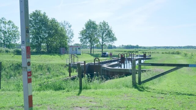 Small canal lock system opening in a rural european landscape