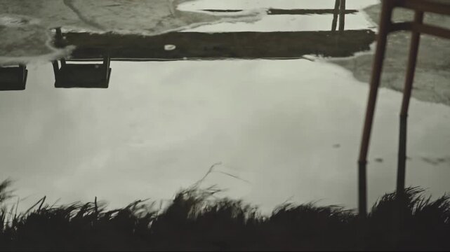 Abstract Reflection of Chair and Grass Roof in Rainwater Puddle After Rain, 4K Video Footage