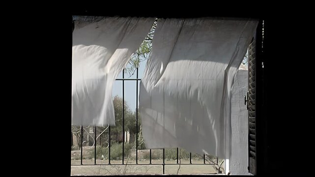Sheer Curtains Blowing in the Wind Through an Open Window with Iron Grille - 4K