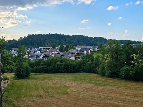 germany, charming elzach village houses surrounded by green trees beneath glowing summer sunset in breathtaking peaceful black forest countryside landscape