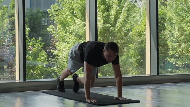 Man doing mountain climber exercise on mat indoors