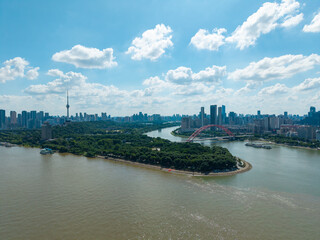 Fototapeta premium A wide aerial view of the modern skyline and a large river bridge in the city of Wuhan in China on a beautiful sunny day