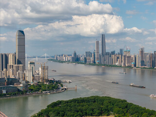 Obraz premium A scenic aerial view of the modern city skyline along the Yangtze River in Wuhan China showing tall buildings and boats on a bright sunny day