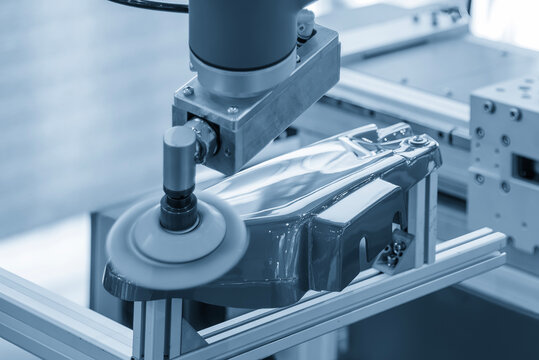 Automated robotic arm performing a high-precision polishing process on automotive parts.