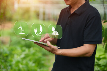 Asian Farmer Using Digital Tablet to Manage Smart Greenhouse and Clean Energy Resources © aekachai