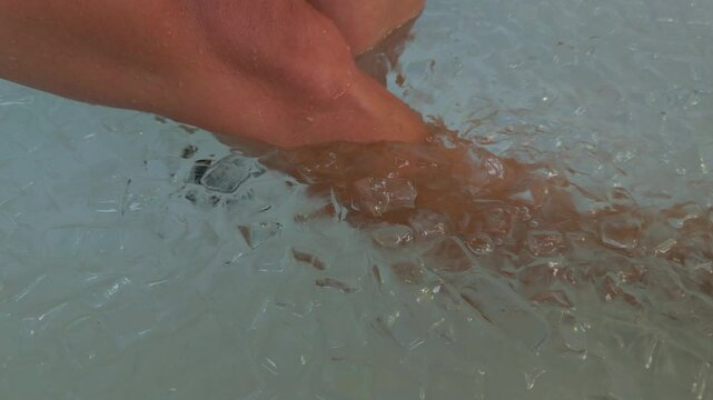 Close View of Woman Feet Submerged Among Ice Cubes in Cold Water, Cryotherapy, Muscle Recovery, Circulation and Physical Endurance