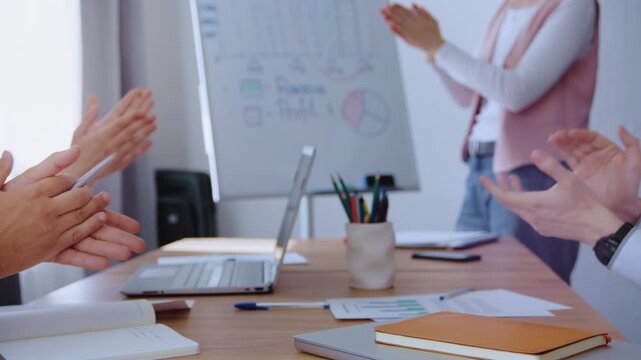 A professional woman shares project outcomes with colleagues during a corporate meeting. The team celebrates success through support and appreciation, showing strong company culture