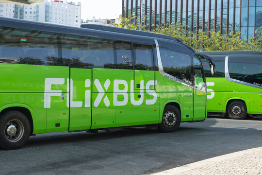 2026-07-09, Lisboa Portugal - FlixBus long-distance coach parked at a bus terminal in an urban setting. The green intercity bus is photographed outdoors with modern city buildings in the background